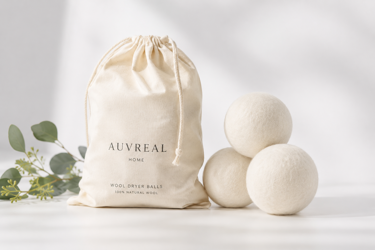 Wool dryer balls with a drawstring bag labeled 'AUVREAL HOME' on a light background.